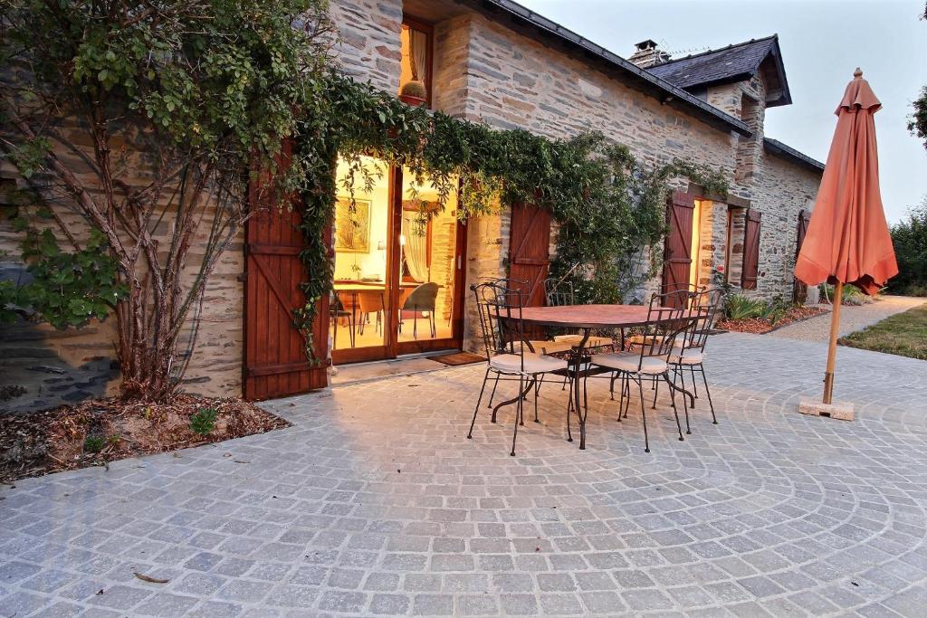 La Chevallerais的住宿－La Longère de La Chevallerais，庭院配有桌椅和遮阳伞。