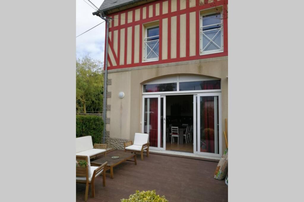 a red and white building with a patio at Les écuries du chateau in Commes