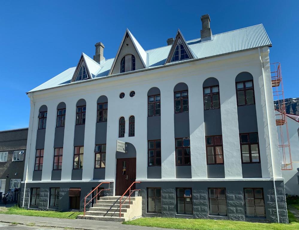 een oud wit gebouw met een wit dak bij Mánagisting Guesthouse in Ísafjörður