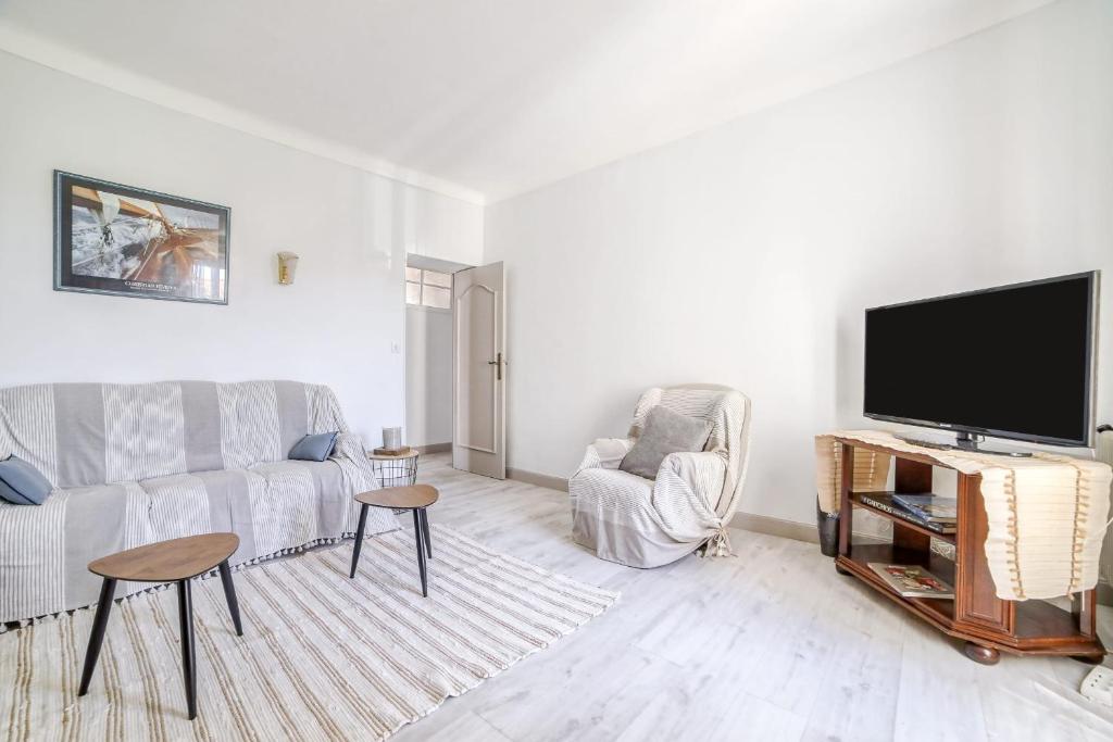 een woonkamer met een bank en een flatscreen-tv bij Charming Apt Near The Croisette in Cannes