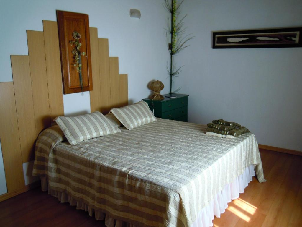 a bedroom with a bed with a striped bedspread at Cabañas Moconá in Dos de Mayo