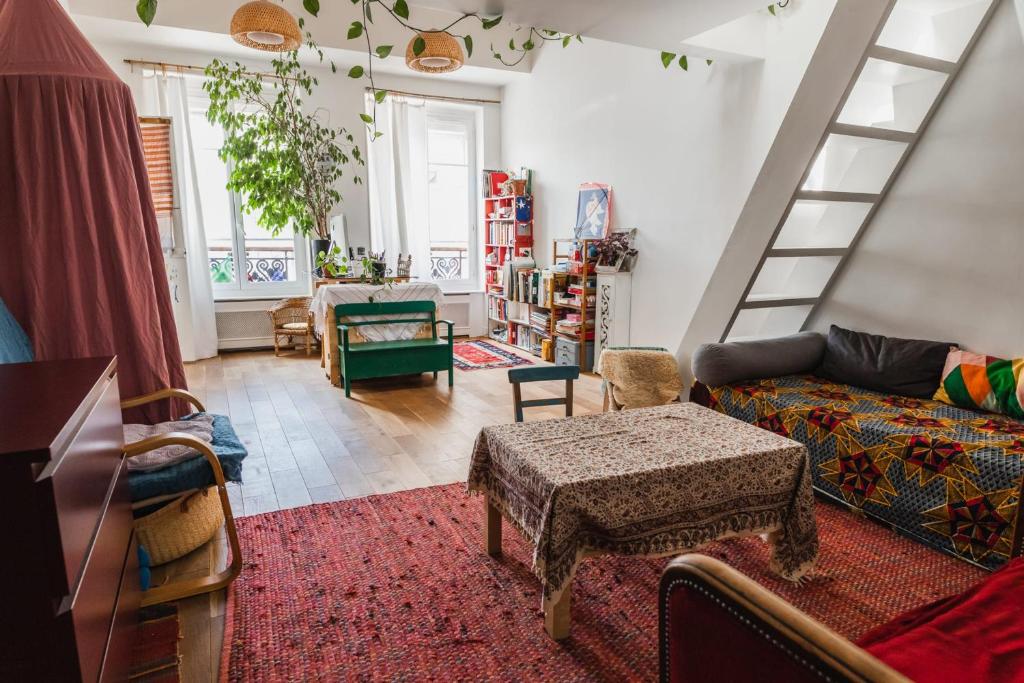 - un salon avec un canapé et un escalier dans l'établissement Bright atypical duplex in Menilmontant, à Paris