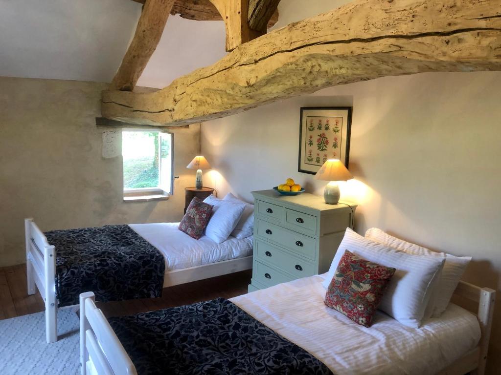 a bedroom with two beds and a couch in a room at Maison Lamothe in Flamarens
