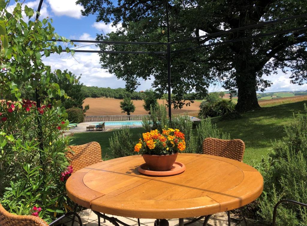 a wooden table with a vase of flowers on it at Maison Lamothe in Flamarens