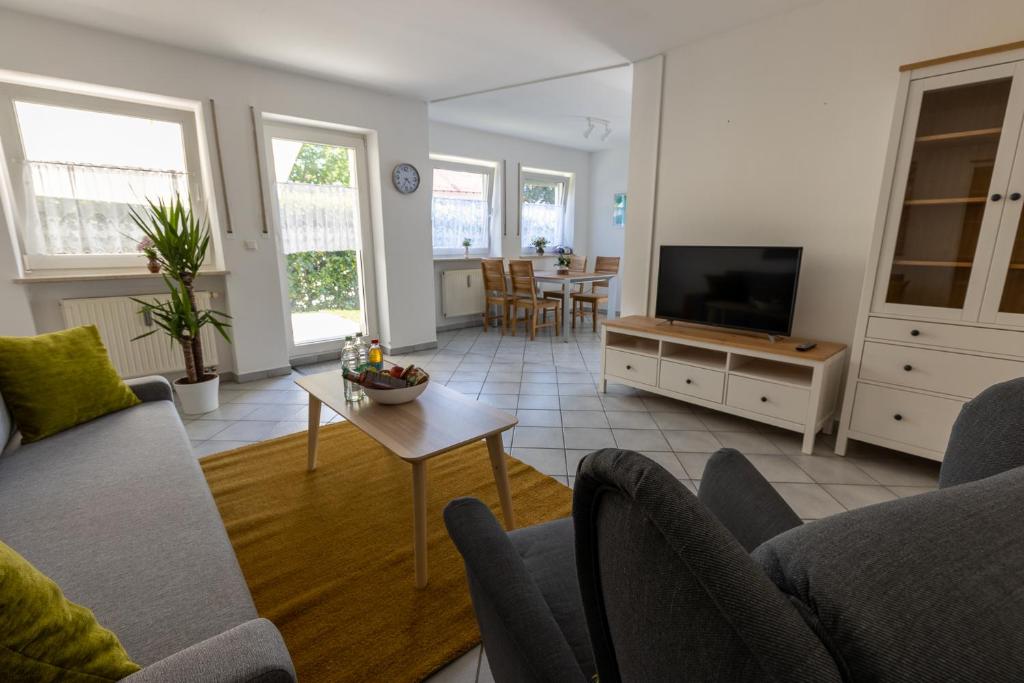 a living room with a couch and a tv at Ferienwohnung Garten in Unterneukirchen