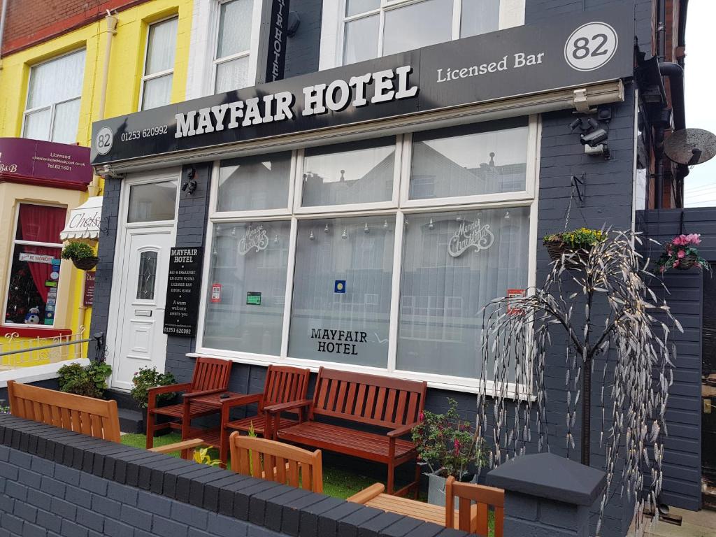 a restaurant with two benches in front of a building at Mayfair Hotel in Blackpool