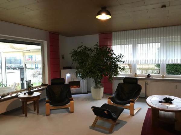 eine Lobby mit Stühlen, einem Tisch und einer Pflanze in der Unterkunft Maxbed in Flensburg