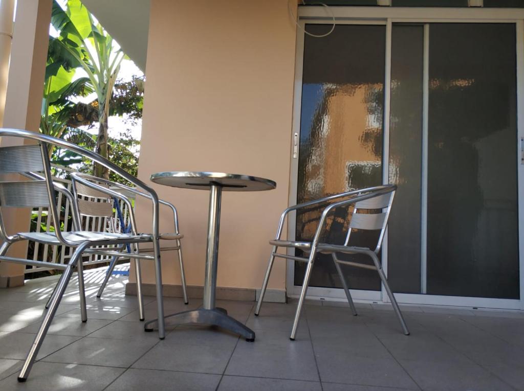 een tafel en stoelen op een veranda bij Mandariniers 97232 in Le Lamentin