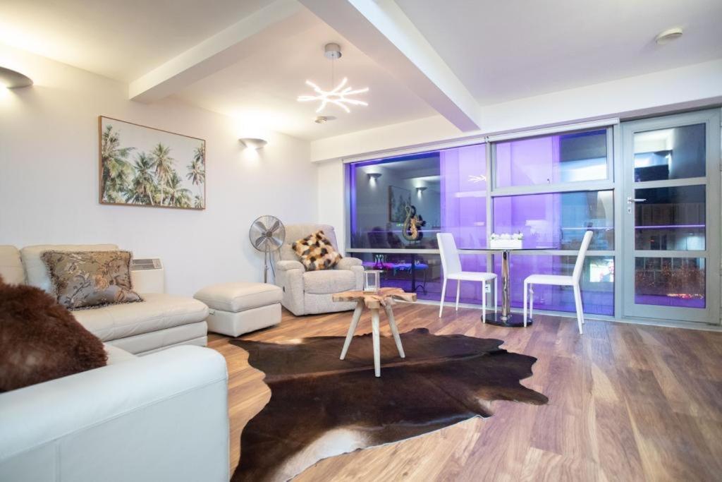 a living room with a couch and a table at Live in Leeds Millenium Square Apartment in Leeds