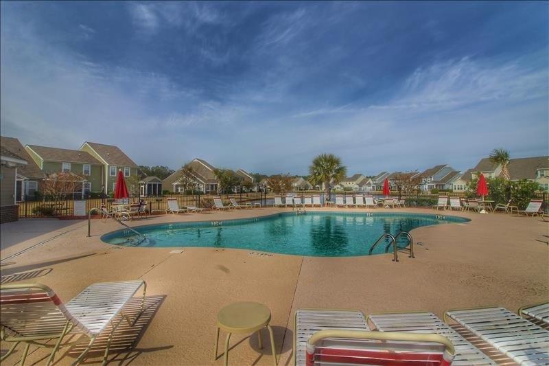 a large swimming pool with chairs and avisorvisor at 612 Egret Run Cabin in North Myrtle Beach