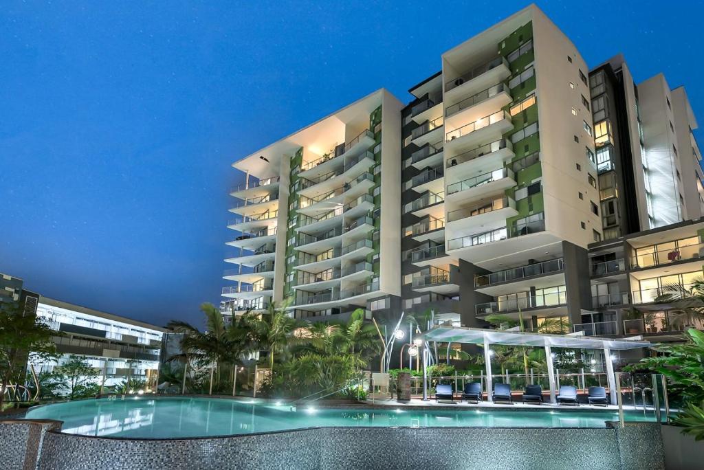 a large apartment building with a swimming pool at night at Urban Edge Apartments by Urban Rest in Brisbane