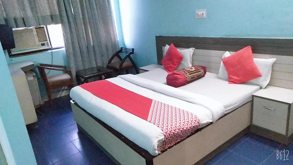 a bedroom with a bed with red pillows on it at Hotel veersarthak residency in Hisār