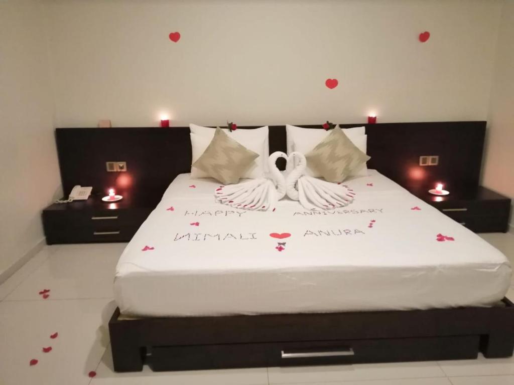 a bedroom with a bed with two swans on it at Kethumathee Hotel & Banquet in Ratnapura