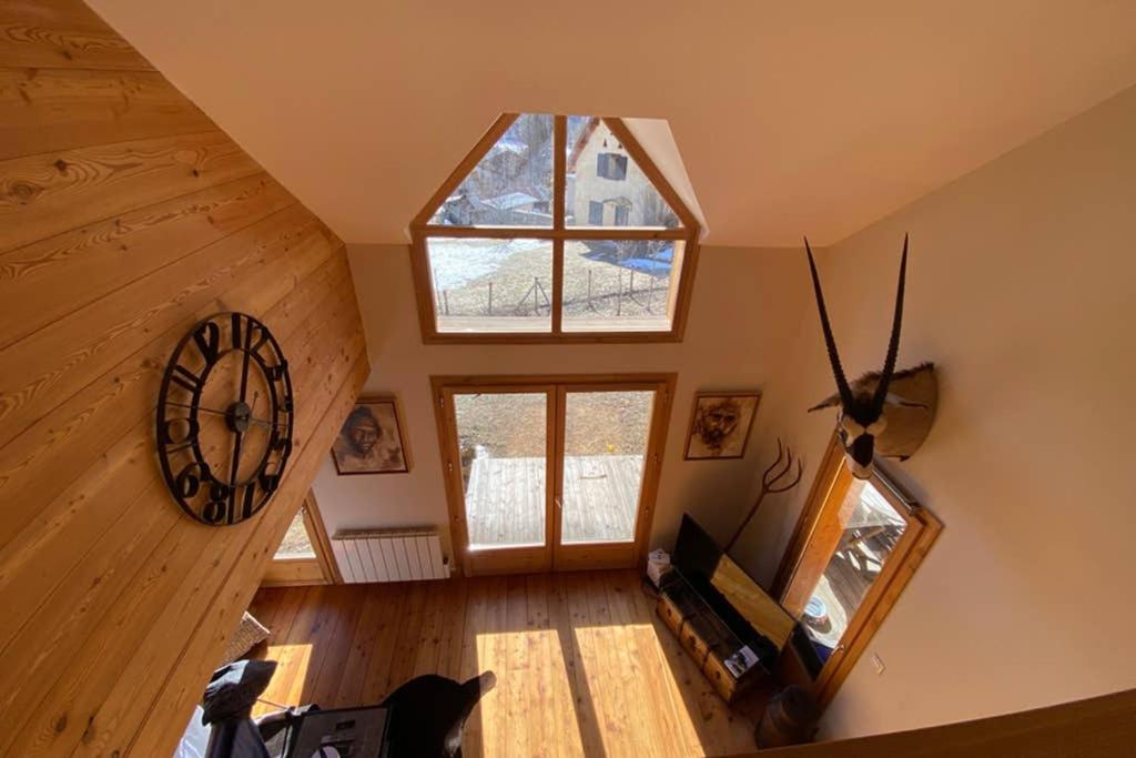 an overhead view of a room with a clock on the wall at Le Serre Barbin - Chalet ensoleillé, tout confort in Le Monêtier-les-Bains