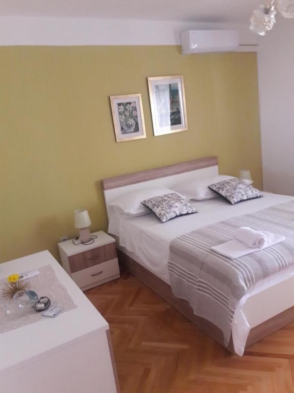 1 dormitorio con 1 cama grande y 2 mesas en Apartments Smiljana Mucić, en Makarska