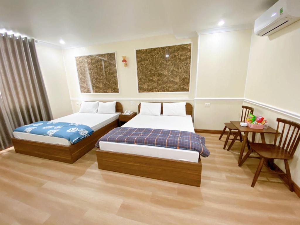 a hotel room with two beds and a table at Đình Vũ 3 Motel in Hai Phong