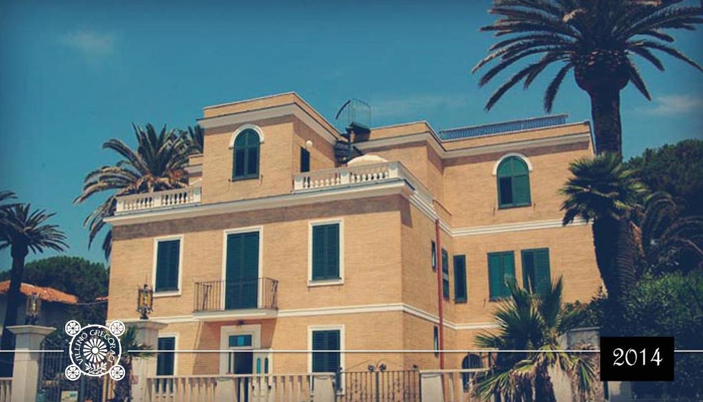 a large building with palm trees on top of it at Villino Gregoraci Relais in Santa Marinella