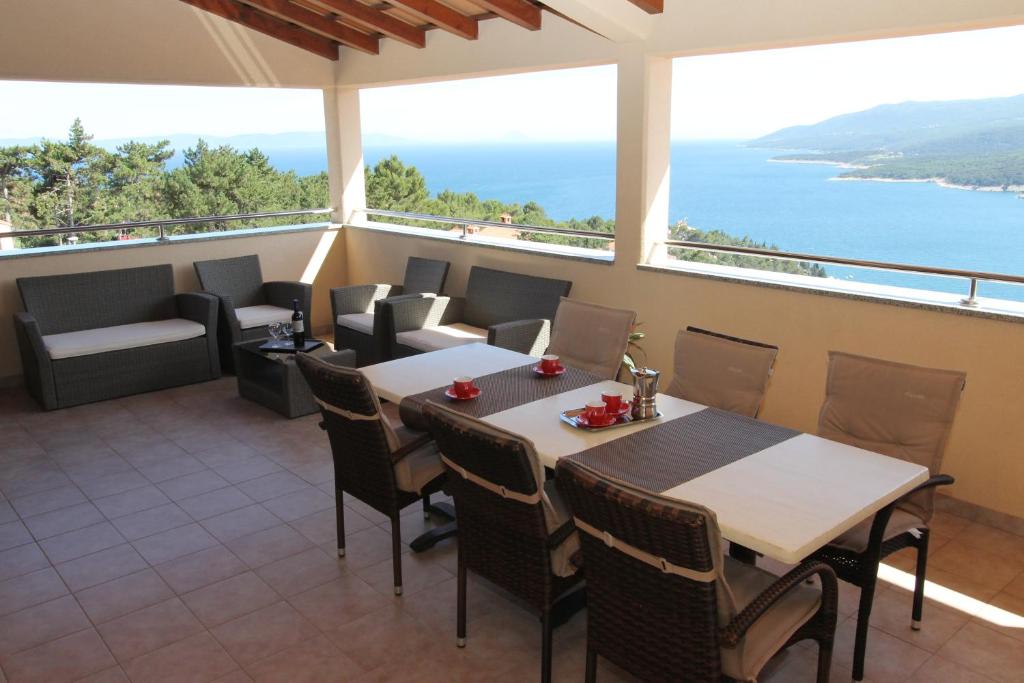 Un balcón con mesas y sillas y vistas al océano. en Apartments Mareblu, en Rabac
