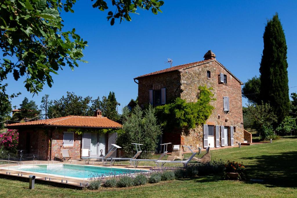 a building with a swimming pool in front of a house at La Bacaia in Marciano Della Chiana