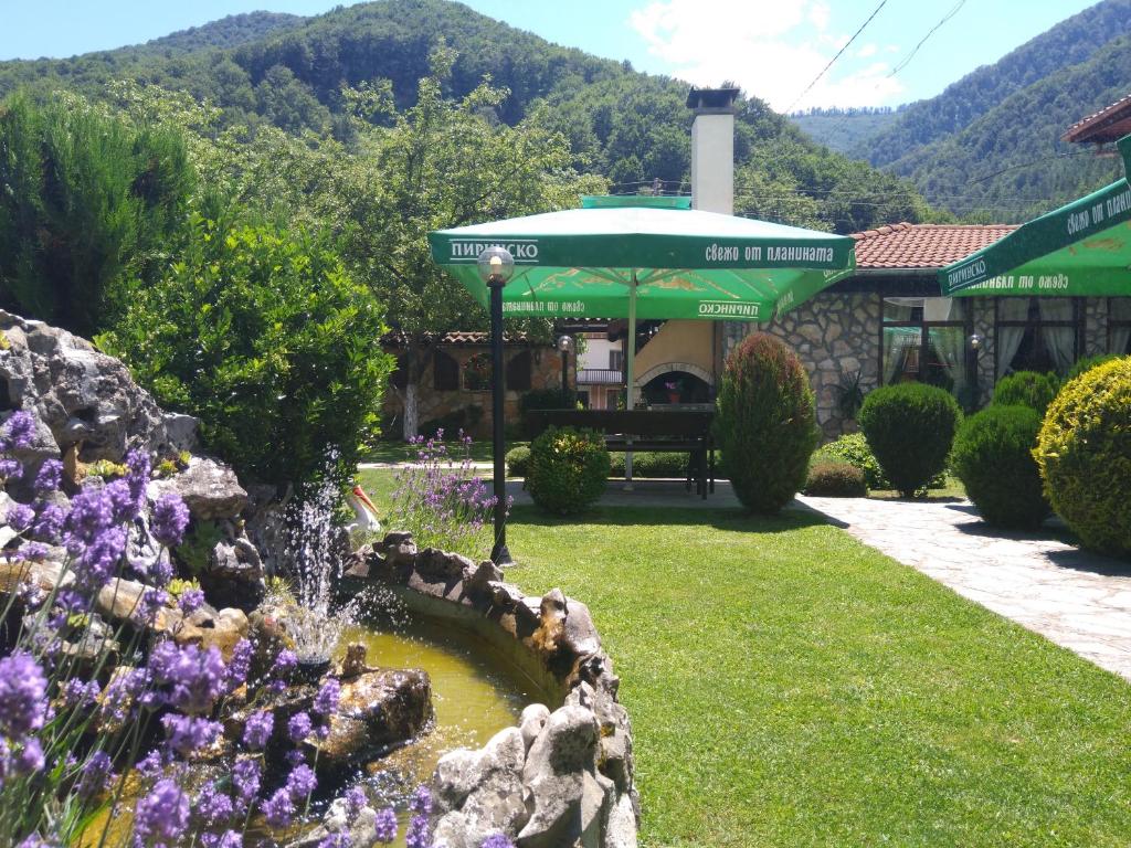 einen Garten mit einem Brunnen vor einem Gebäude in der Unterkunft СТАР МЕРАК in Ribarica