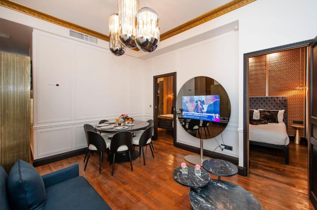 - un salon avec une table, des chaises et une télévision dans l'établissement LE MARAIS PRESTIGE Luxueux - Cosy - Wifi, à Paris