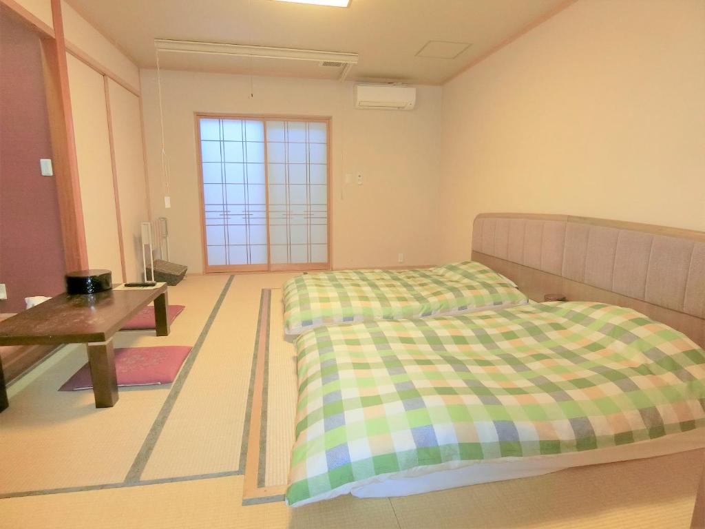 Postel nebo postele na pokoji v ubytování Yurakuan Miyazaki