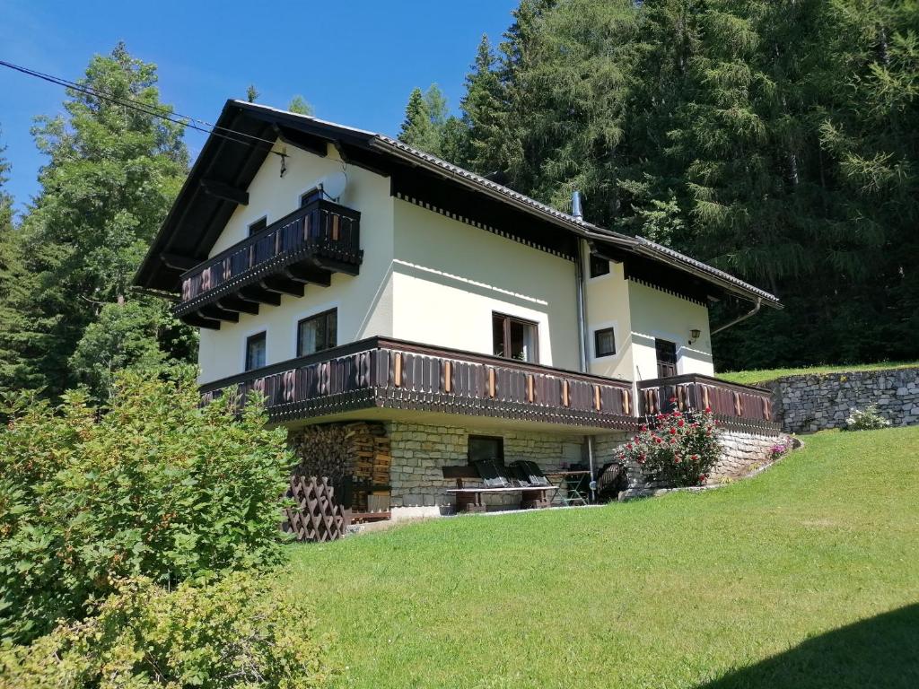 uma casa grande com uma varanda numa colina em Ferienhaus Stubalpenblick em Salla