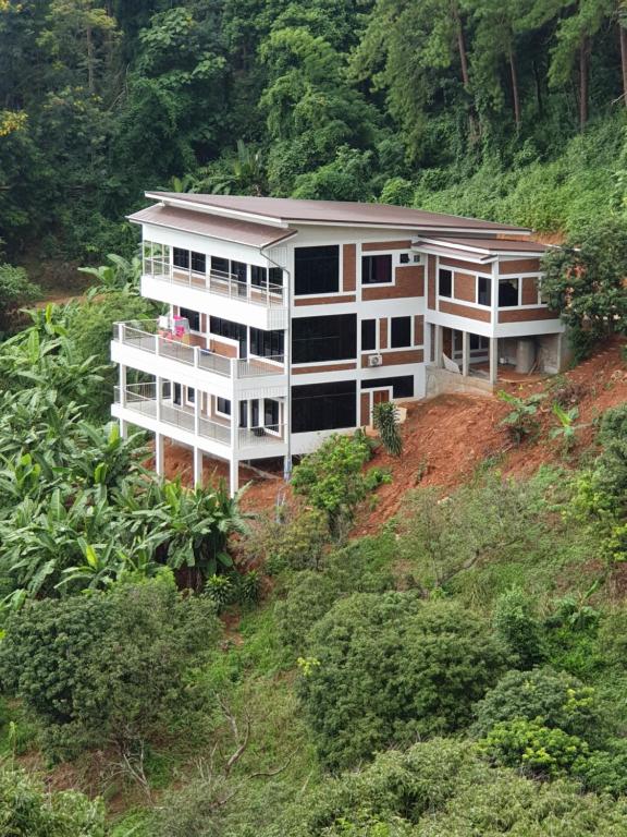 a building on top of a hill with trees at DOI TUNG Anisa Homestay in Chiang Rai