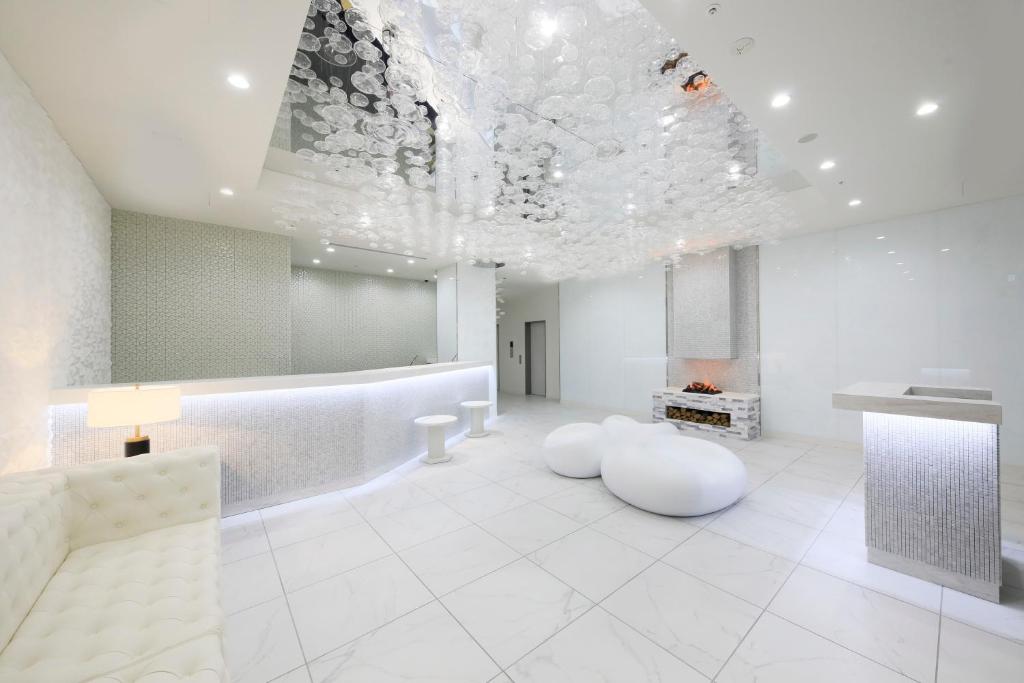 a large white room with a fireplace and a ceiling at Quintessa Hotel Sapporo Susukino in Sapporo