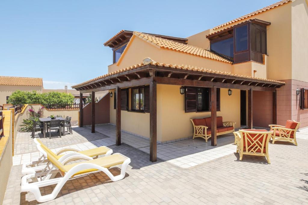 eine Terrasse mit Stühlen und ein Haus in der Unterkunft Casa Maria Granillo in Costa Calma