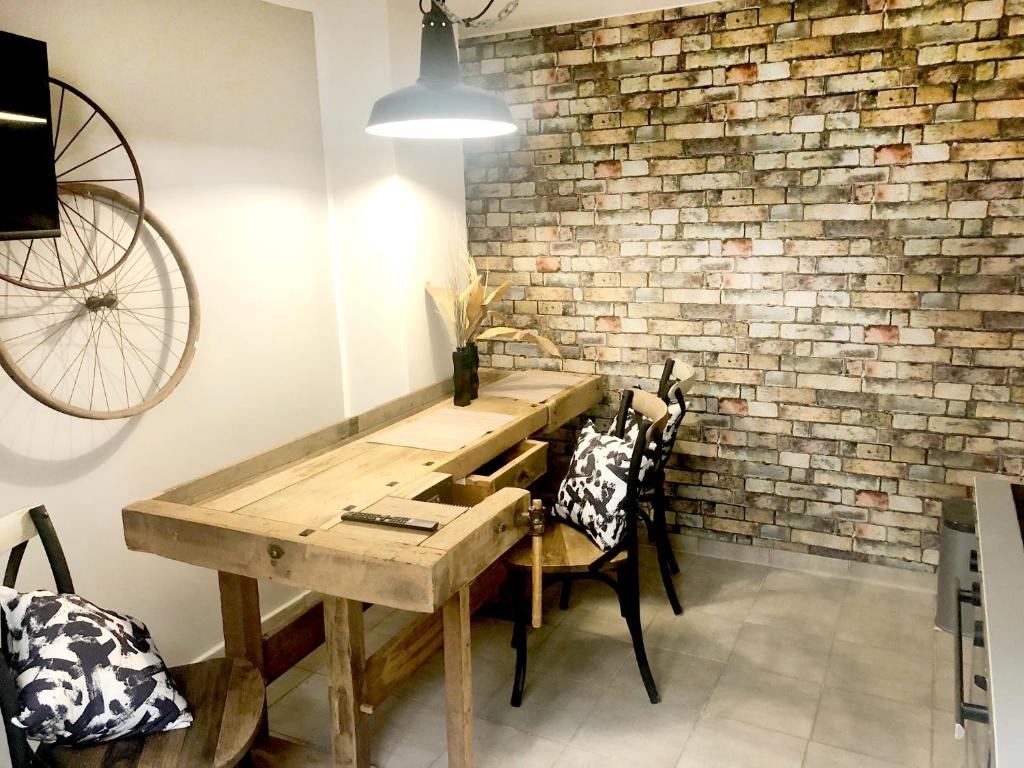 een kamer met een houten tafel met stoelen en een bakstenen muur bij Rudis Werkstatt in Bremen