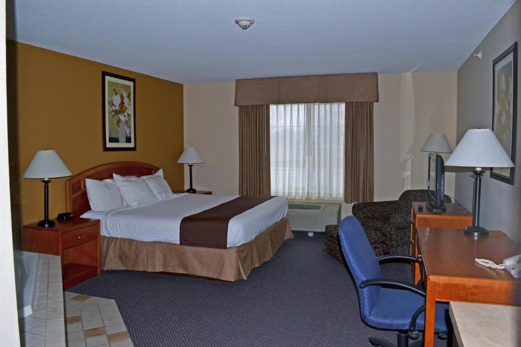 a hotel room with a bed and a desk at Paola Inn and Suites in Paola
