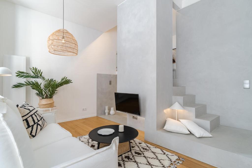 a white living room with a white couch and a table at Casa Boma Lisboa - Duplex Apartment In The Heart Of Lisbon - Arroios I in Lisbon