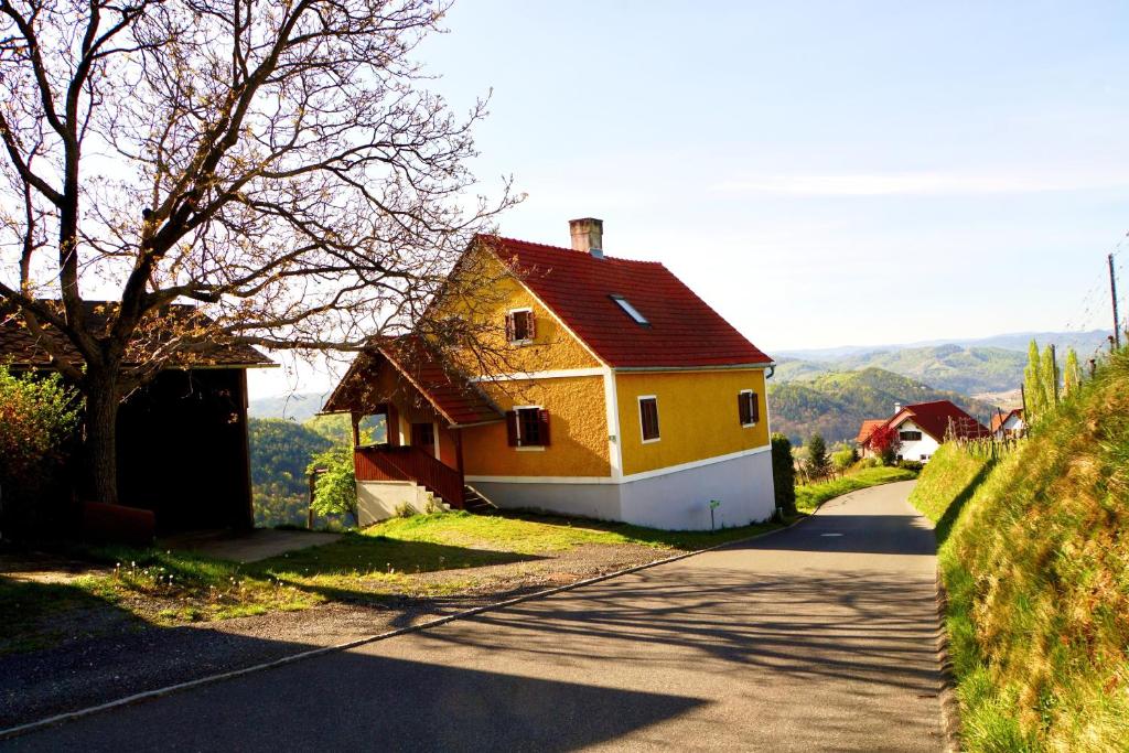 ein gelbes Haus am Straßenrand in der Unterkunft Ferienhaus Haring in Kitzeck im Sausal