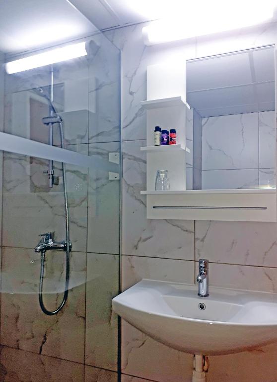 a bathroom with a shower and a sink and a mirror at Marina Hotel in Ayia Napa