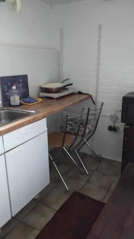 a kitchen with a counter with two chairs and a table at Bel Air in Norderstedt