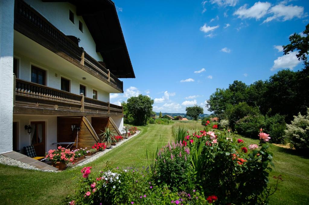 einen Garten neben einem Gebäude mit Blumen in der Unterkunft Gaestehaus Hofer in Bad Birnbach