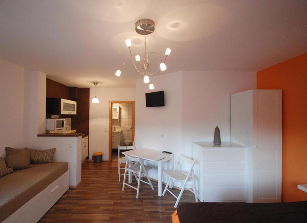 sala de estar y cocina con mesa y sofá en Apartment Visak en Bled