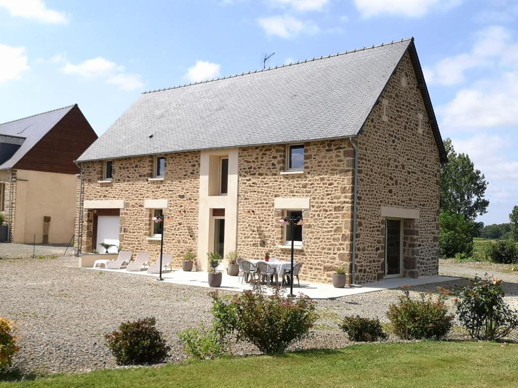 a large brick building with a table in front of it at Mon Pré Vert in Saint-Ellier-du-Maine