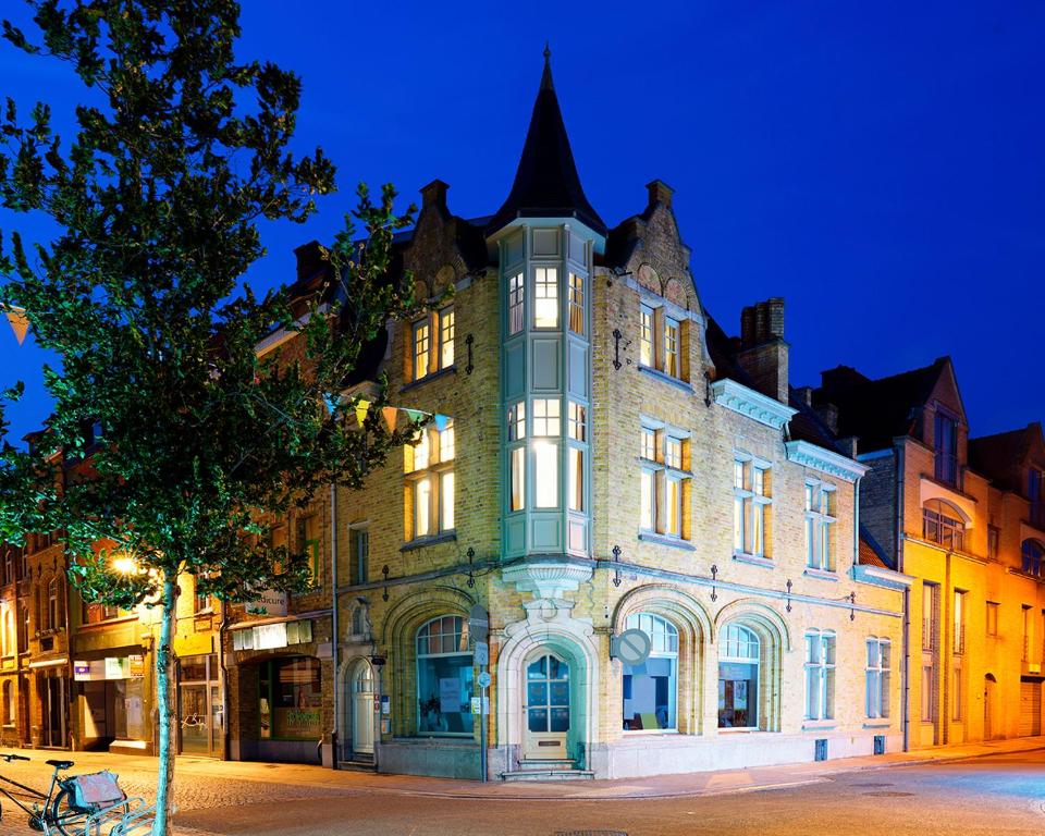 un antiguo edificio con una torreta en una calle por la noche en Apartments Ypres en Ypres