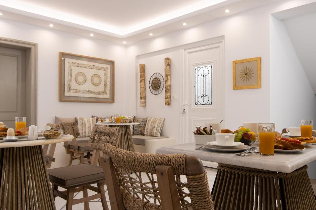 ein Wohnzimmer mit einem Tisch und Stühlen sowie einem Frühstücksraum in der Unterkunft Hotel Villa Flora in Naxos Chora