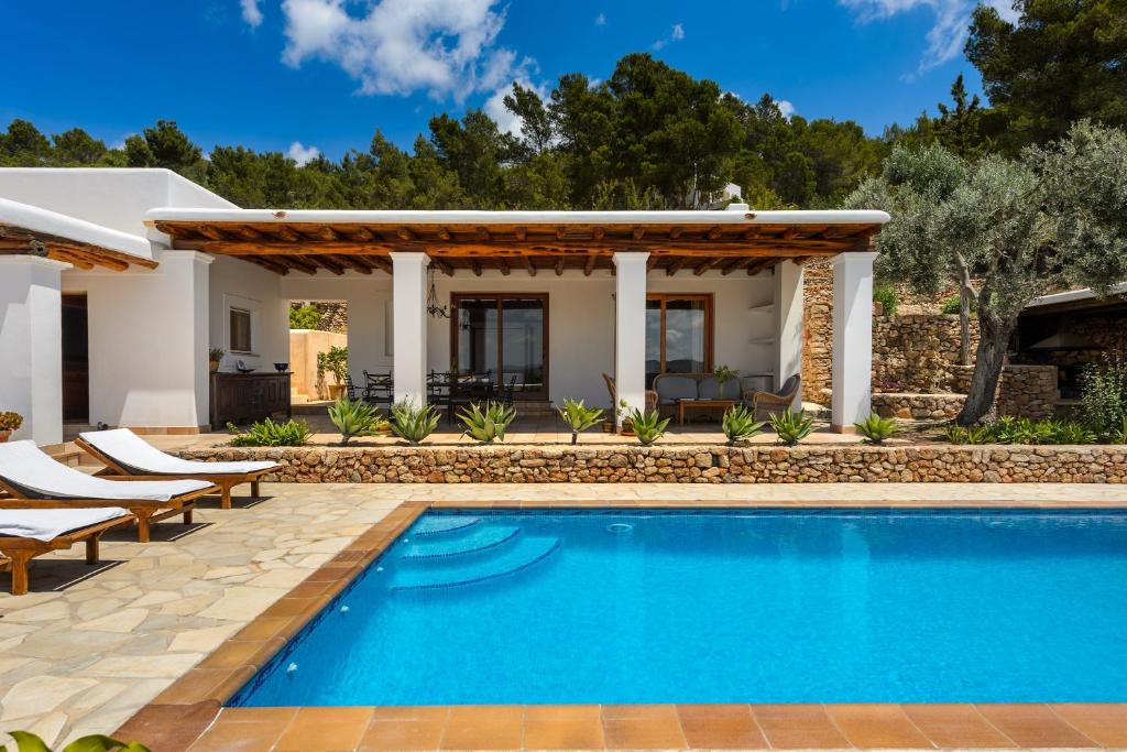 a villa with a swimming pool and a house at Can Palau in Sant Joan de Labritja