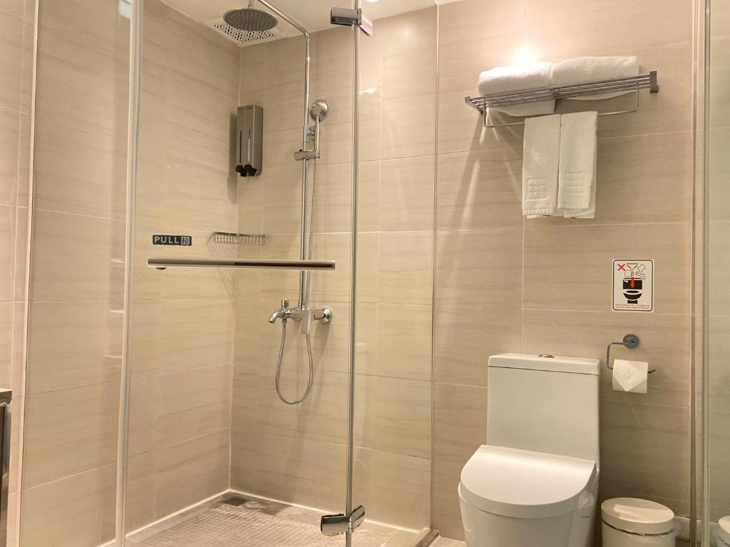 a bathroom with a glass shower with a toilet at Hotel Midtown Richardson in Taipei