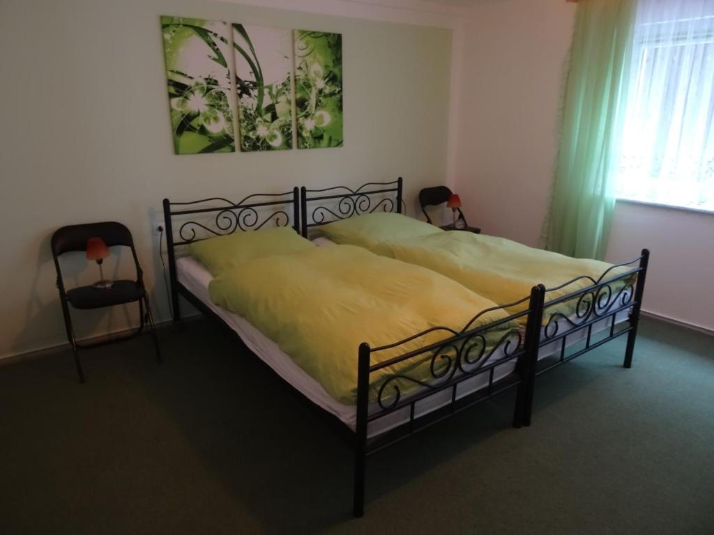 a bedroom with a bed with a yellow blanket at Ferienhaus Johanna in Weischlitz