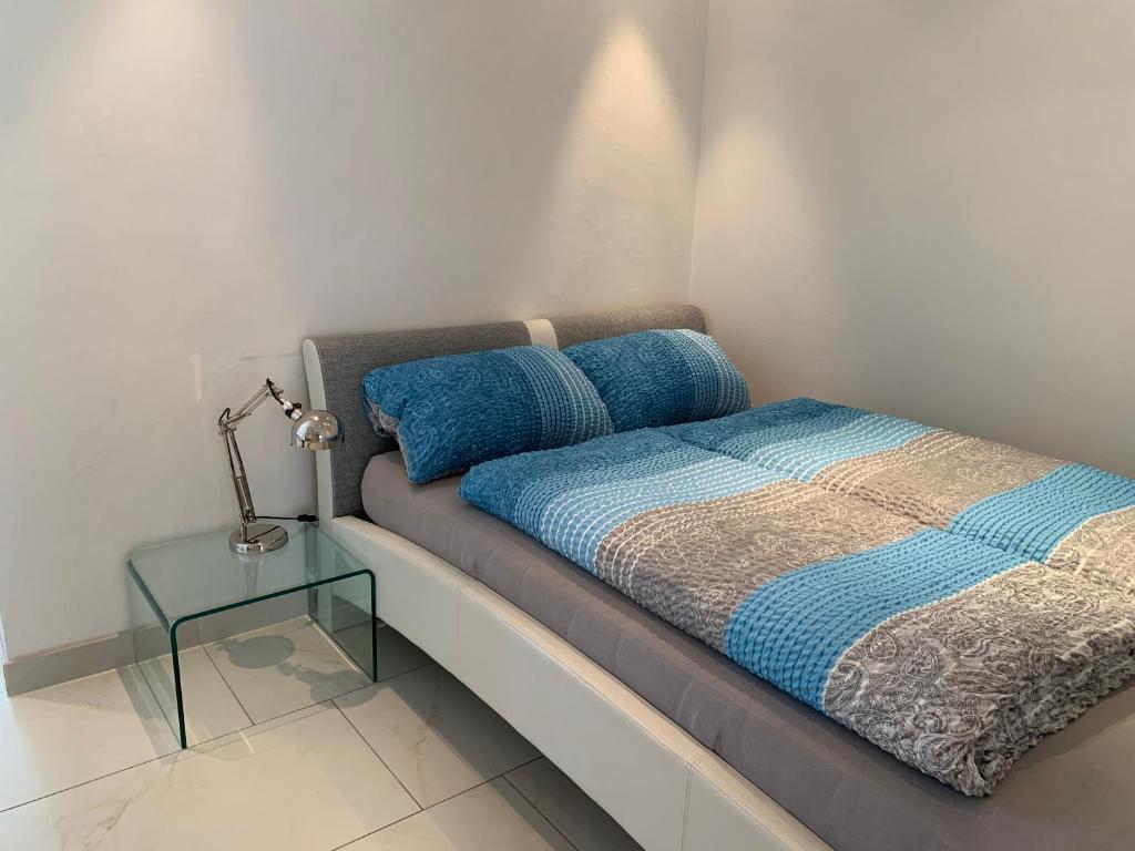 1 dormitorio con 1 cama con lámpara y mesa en City Apartments en Bad Säckingen
