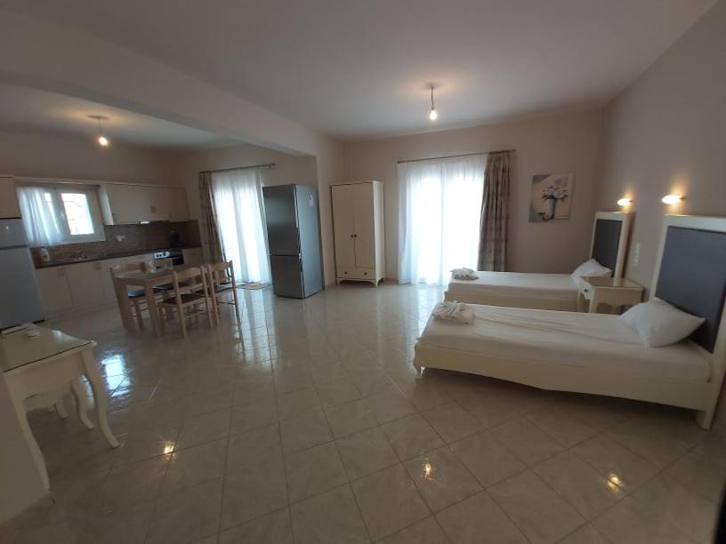a large living room with a couch and a kitchen at Konstantinos Apartments in Ammoudia