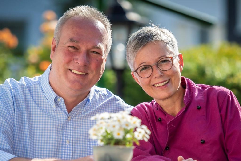 een man en een vrouw die samen met bloemen zitten bij Wüllner's Landgasthof in Schmallenberg