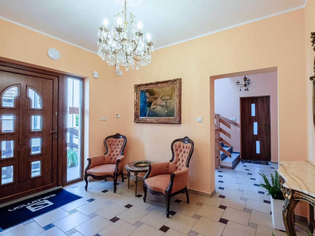 un couloir avec des chaises, une table et un lustre dans l'établissement Villa Nicolo, à Władysławowo