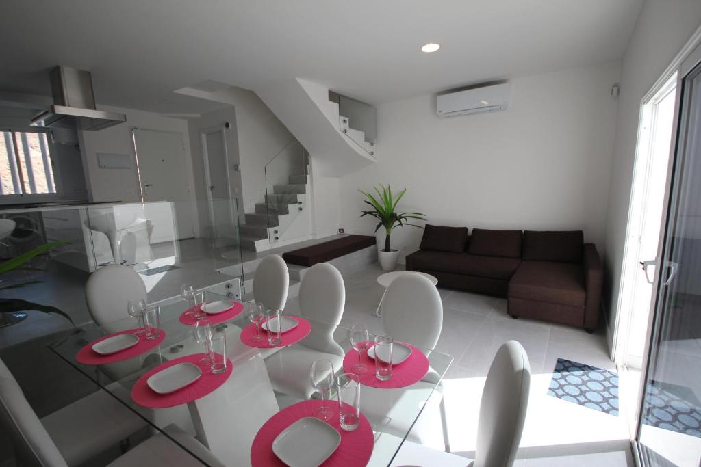 a living room with red tables and white chairs at El Rayón in Morro del Jable