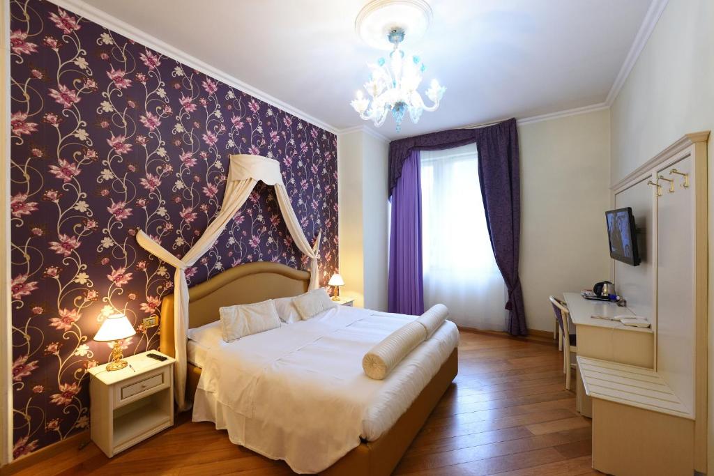 a bedroom with a bed and a wall with flowers at Relais La Corte di Cloris in Florence